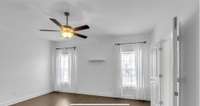 Primary bedroom with two windows, a ceiling fan, and laminate flooring