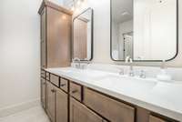 Primary bath features dual vanities with modern finishes