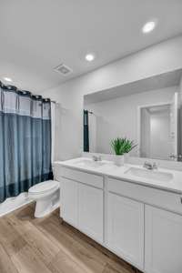 The spacious secondary bathroom features double vanities and a convenient shower-and-tub combination—perfect for comfort and functionality.
