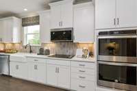 Home will have a Wall Oven/Microwave with a Wood Hood and Gas Cooktop! Gourmet Kitchen! Photos are of model home.