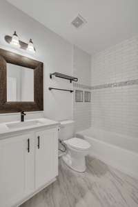 Full Bath for Bedroom #2. New quartz countertop + faucets, brand new tub w/tile surround and high end toilet, tile flooring and new hardware on the cabinets.