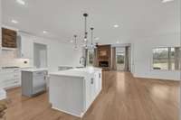 Here is the focal point of the house-this open floor plan allows you to entertain or be present as you prepare meals. Look at all the natural light coming through! The fresh paint and white oak floors help create a warm and inviting atmosphere.