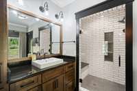 Spa-inspired bath with walk-in shower, wood vanity, and classic black-and-white palette.