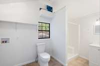 Well-lit bathroom with walk-in shower and laundry hookups!