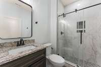 Full bath with custom tile shower in the first floor hall, next to the bedroom.