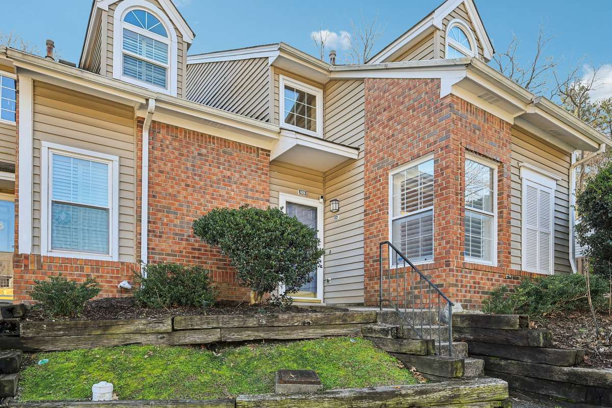 Classic curb appeal with charming brickwork and beautiful dormer windows in a peaceful community setting.