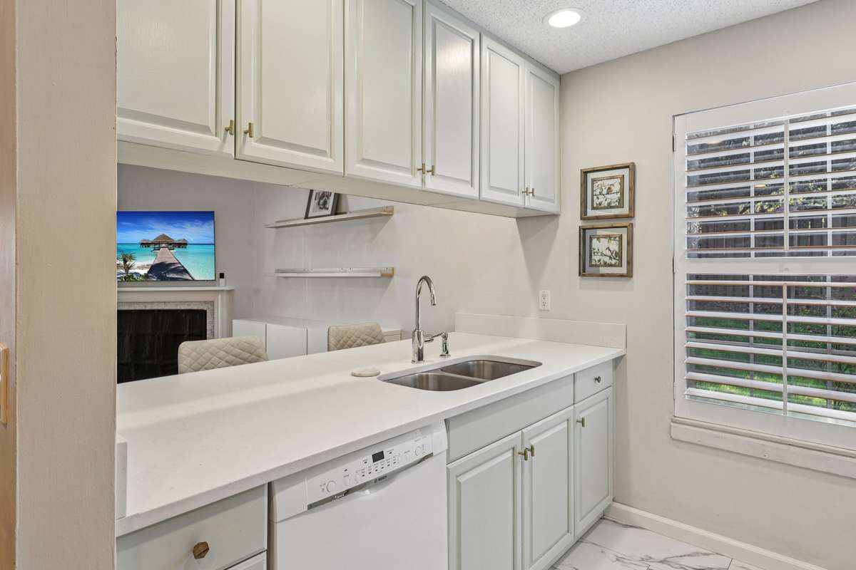 Double stainless steel sink and breakfast bar overlook the living room and fireplace—ideal for entertaining or keeping conversations flowing.