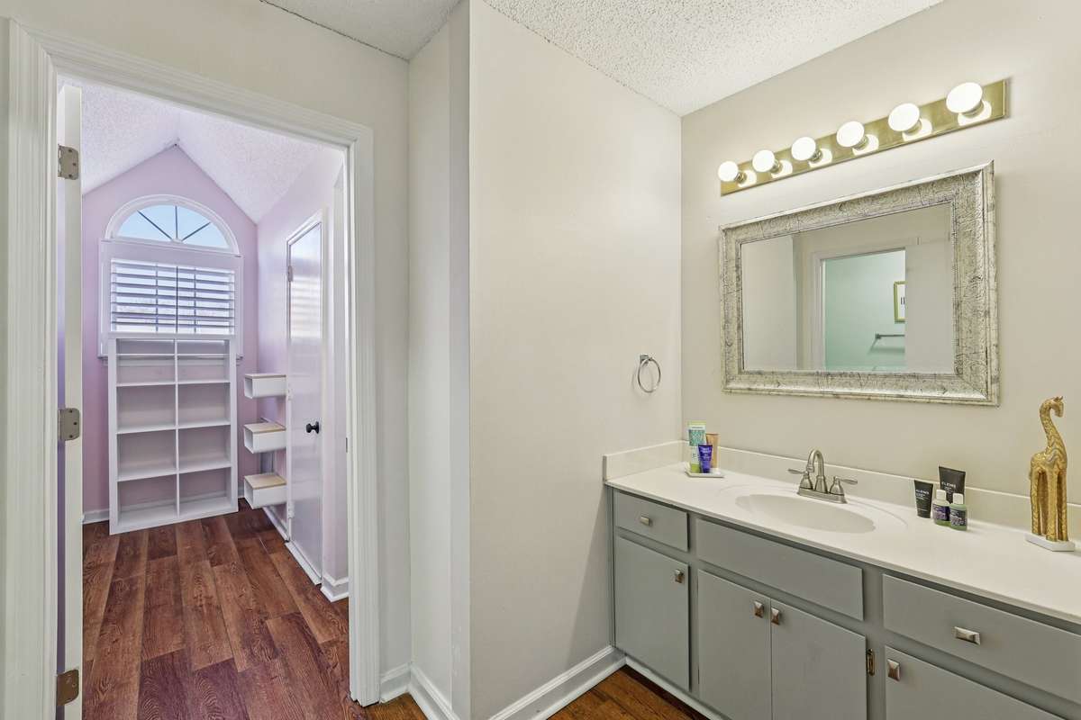 This bright walk-in closet or flex space features built-in shelving and a transom window—perfect for extra storage or a quiet reading nook.