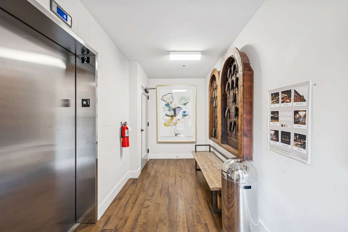 Interior hallway to front door with elevator.