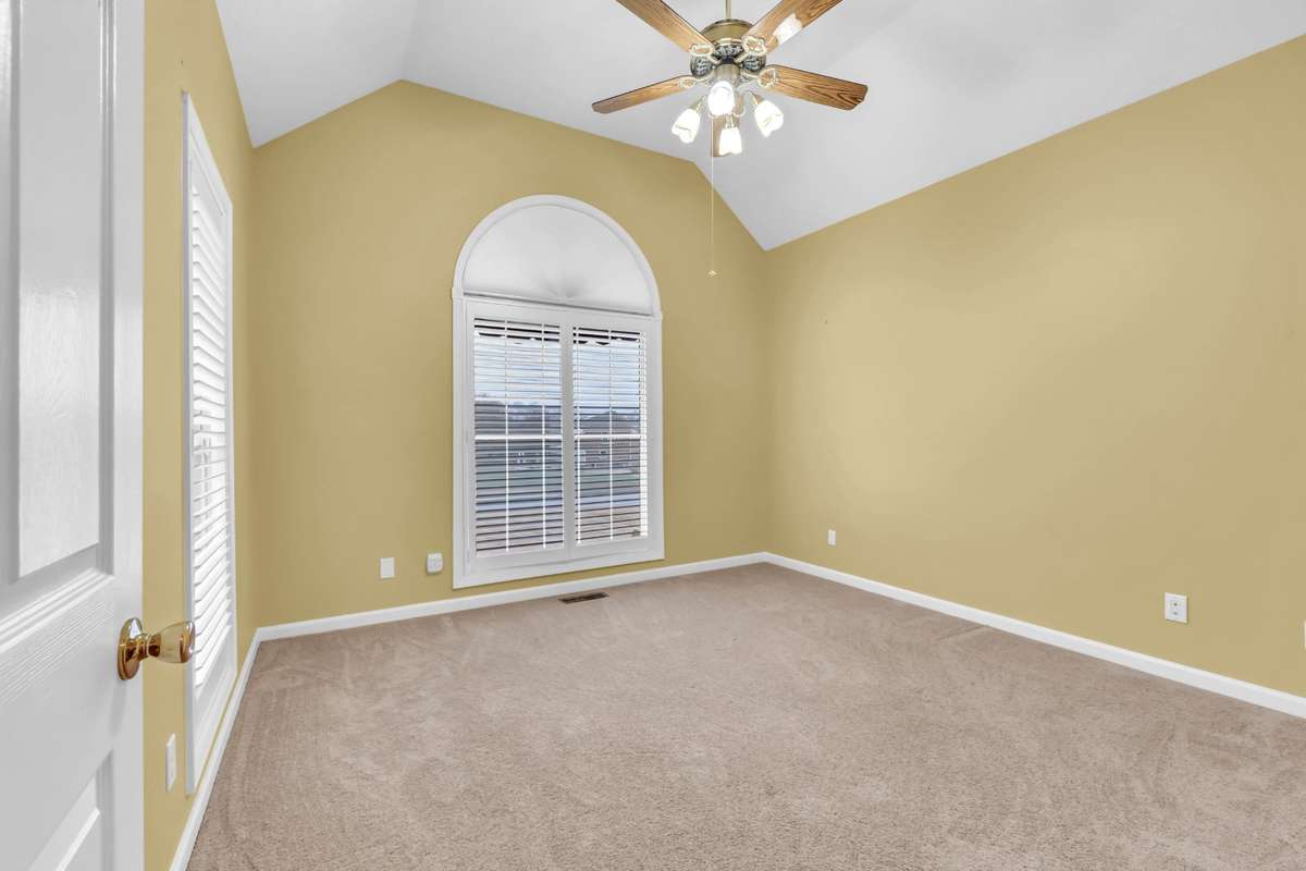 Bedroom 2 with vauilted ceiling & round top window for perfect natural light
