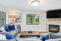 Natural light fills the living room, offering tranquil views of the surrounding greenery and a relaxing ambiance year-round.