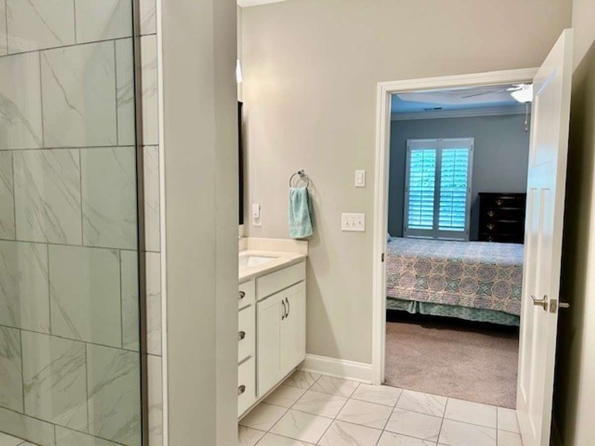 A view from primary bathroom into primary bedroom.