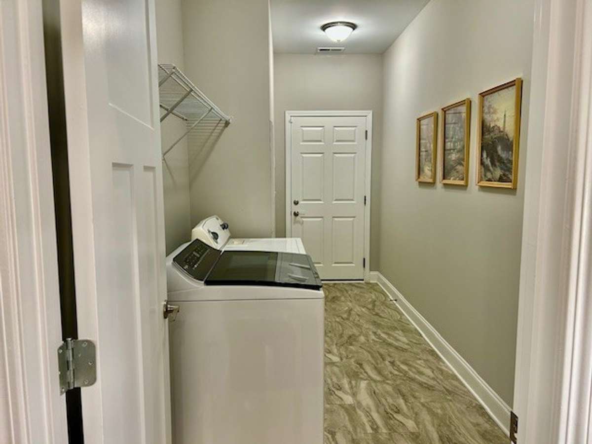 This spacious utility room is nestled between the kitchen and garage.