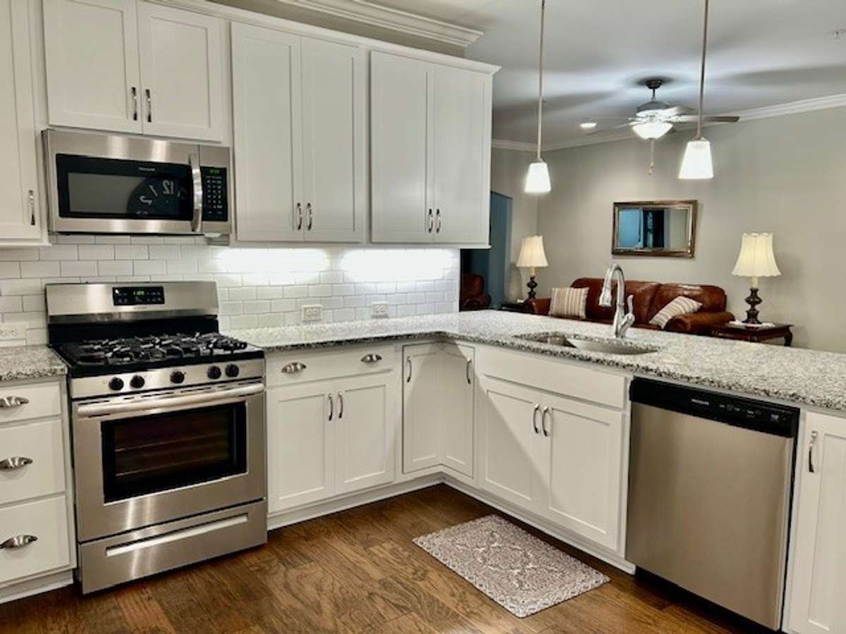 This kitchen has a stainless steel microwave, dishwasher, and gas range.