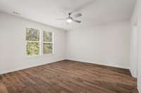 Large Primary Bedroom with views of the tree-lined lot