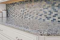 Beautiful granite and tasteful tile backsplash