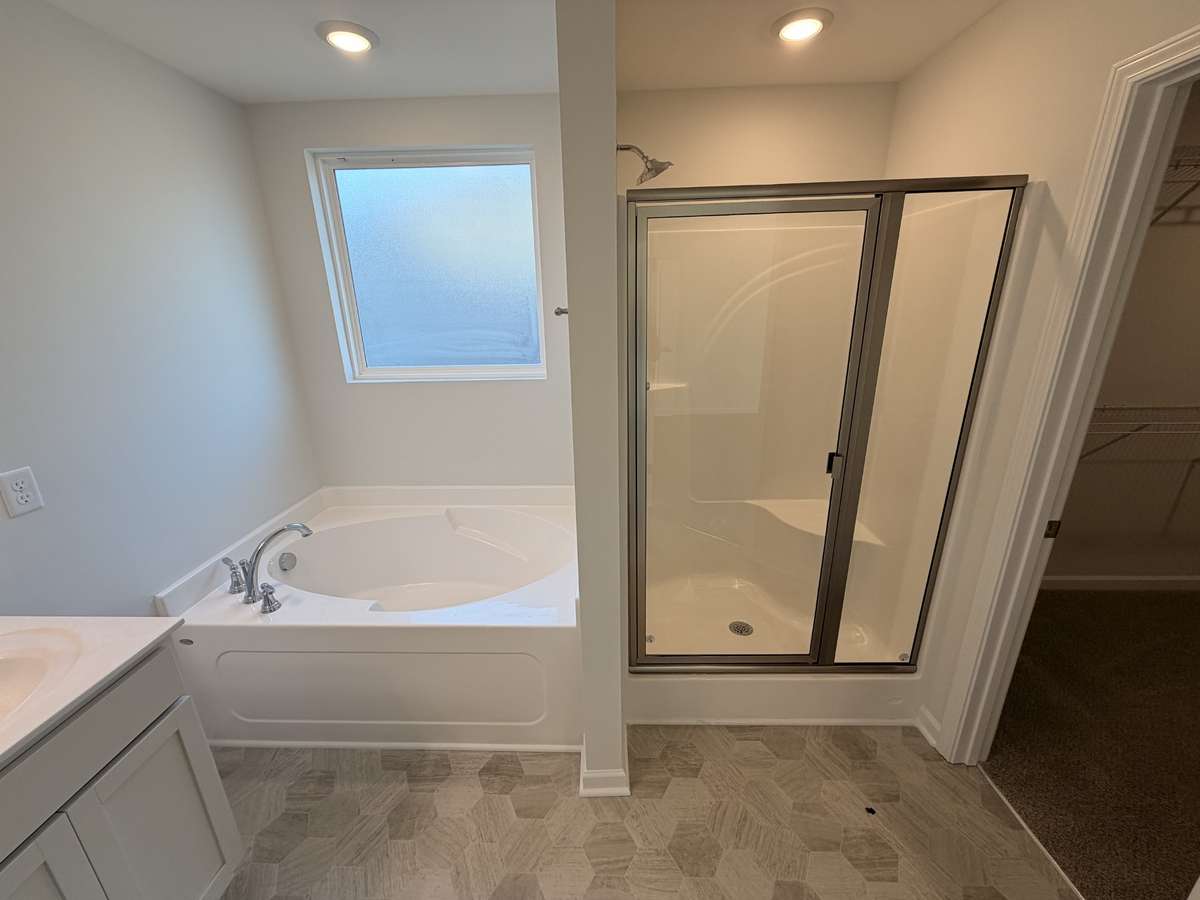 Showcasing the easy clean fiberglass walk in shower & garden tub with obscure window!