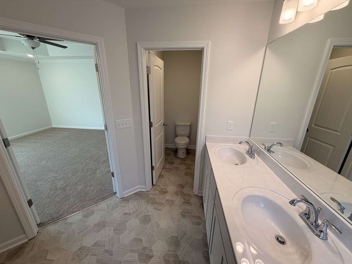 Primary Bathroom features: The easy clean vinyl flooring, double sink bowl, raised vanity, separate toilet room, fiberglass shower, garden tub and extra large walk in closet!