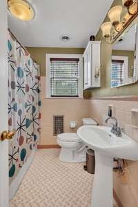 Primary bathroom located in hallway between dining room and the bedrooms