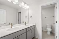 Hallway bath on 2nd level with double vanity, quartz countertops, and separate water closet/shower room