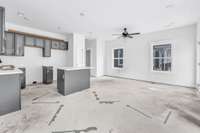 Custom cabinetry with quartz counters, stainless steel appliances and pantry is open to the living room