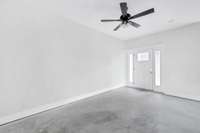 Living room is open to the kitchen and dining rooms and features LVP flooring and ceiling fan