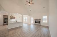 Spacious Living Room with a Stone Fireplace, Floating Wood Mantle, 2 Story Ceiling and Access to the Large Patio!