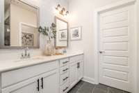 Primary Bath w/ double vanities, quartz countertops, and tile shower *Photos not of exact home*