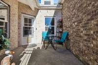 Charming private fenced patio with a small patch of grass.