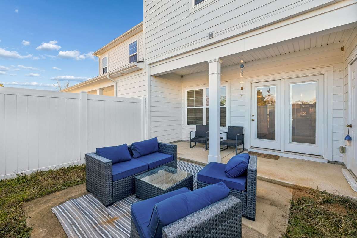 Outside you'll find a covered patio and plenty of room to add additional outdoor seating options as shown in this photo.