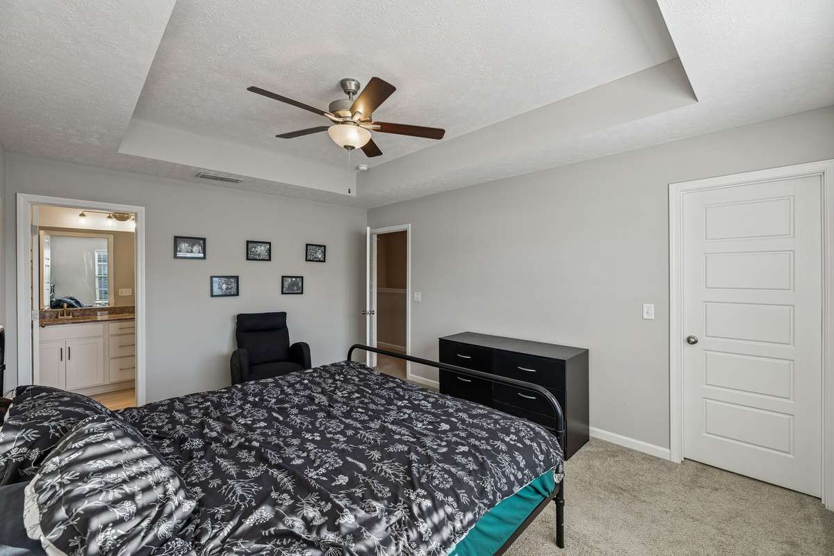 You can see the en suite bathroom in this view of the primary bedroom and the closed door to the right is the walk-in closet.