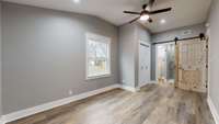 Primary bedroom with a beautiful barn door leading into the full bath