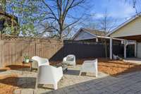 Stone patio in fully fenced backyard.