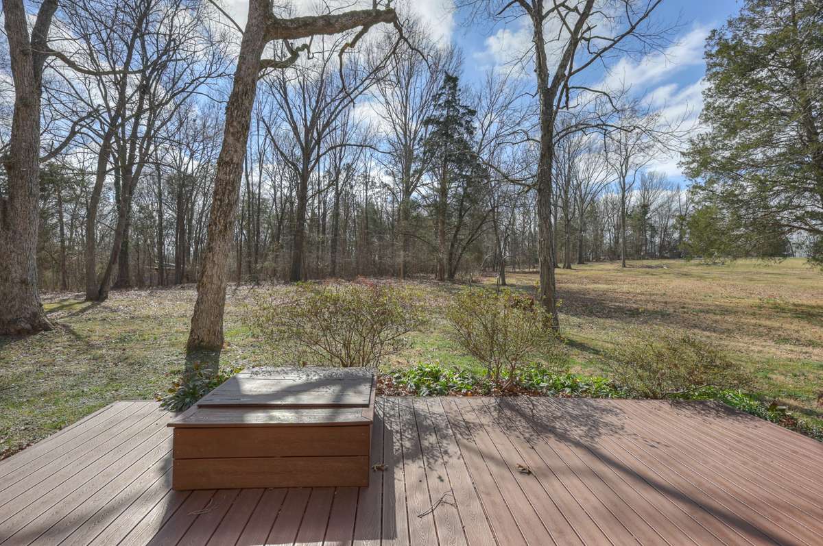 Enjoy the outdoors on the deck. The property line goes into the wooded area