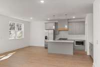 The kitchen is outfitted with sleek stainless steel appliances, a stylish vent hood, and a gas range--perfect for the home chef who loves both form and function.