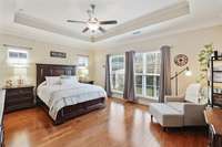 This oversized master suite offers abundant natural light, beautiful hardwood floors, and a generous nook perfect for a seating area.