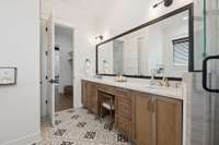 The spa like primary bath features a luxurious soaking tub, ornate tile work, double vanities, and a walk-in shower. A peaceful space designed for comfort and relaxation.