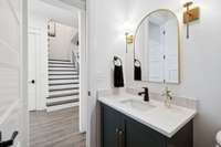 Convenient main level powder room for guests with modern finishes and ornate tile details. A thoughtfully designed space that blends style with everyday practicality.