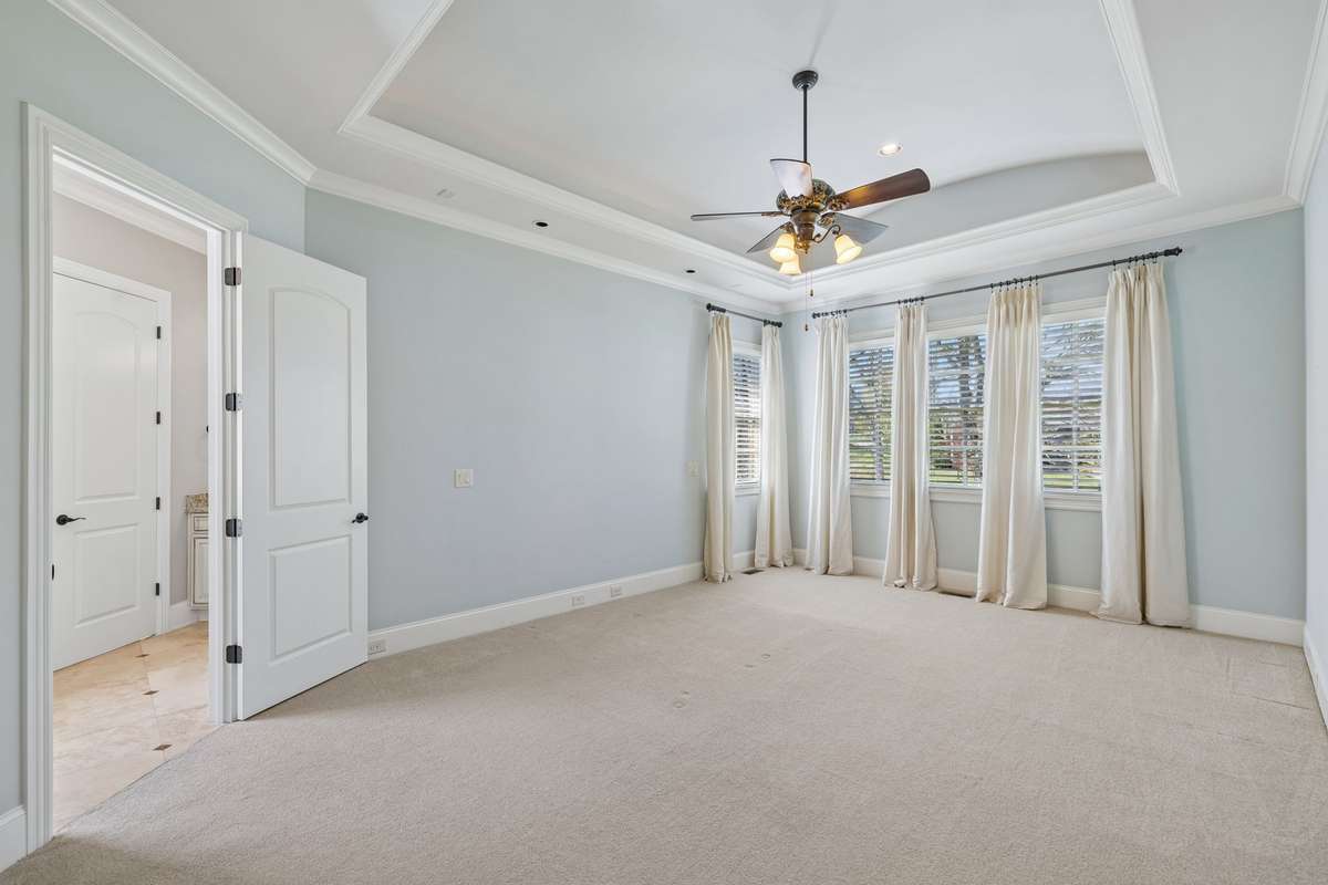 Primary bedroom with special ceiling cove treatment.  Cove lighting.  Also reading lights above headboard area.