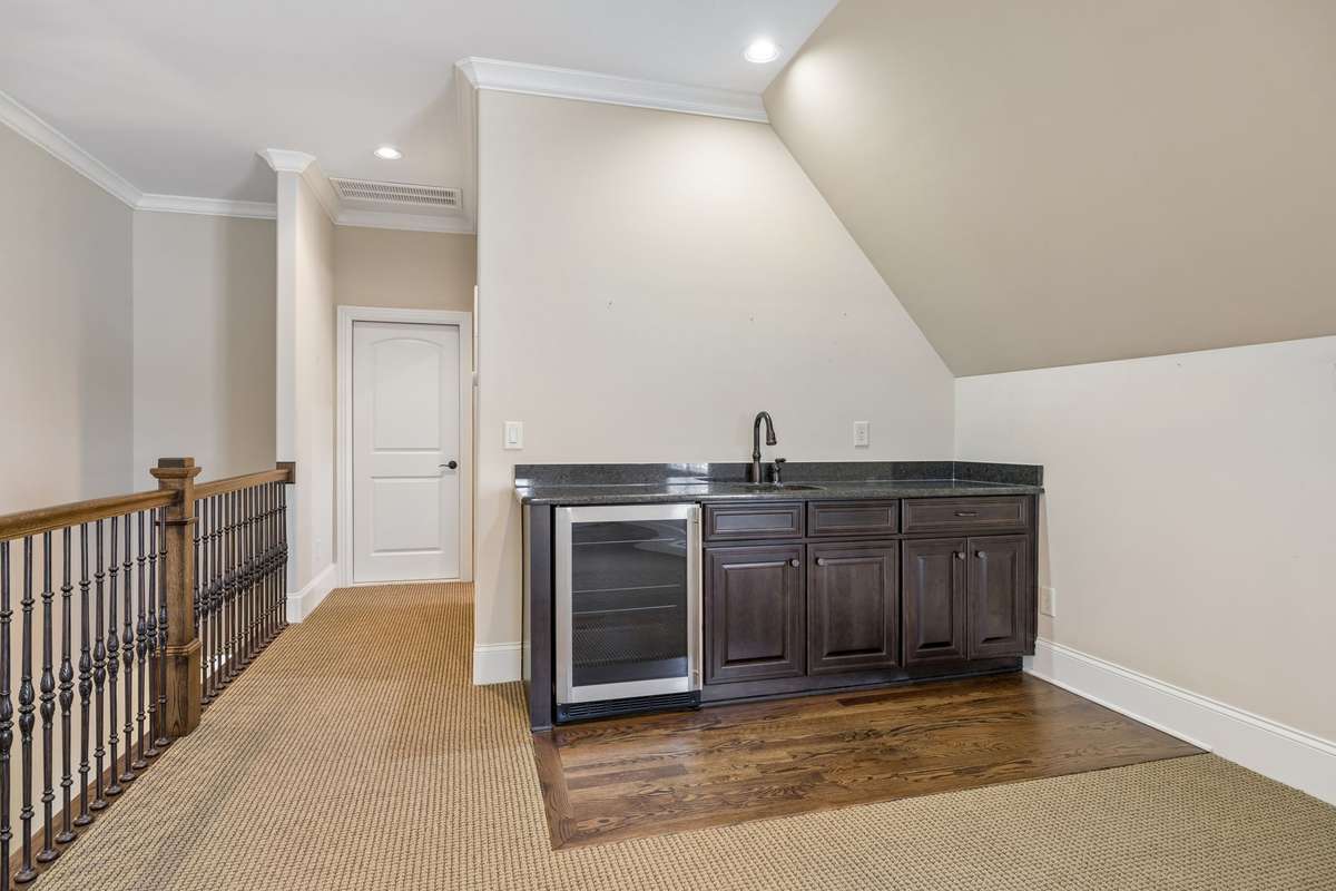 A wet bar with sink and beverage refrigerator complete this entertainment space.