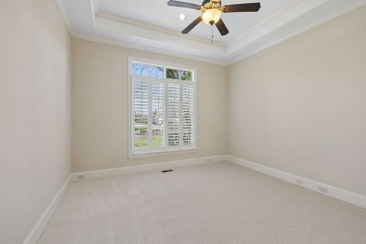 Secondary bedroom with elevated ceiling treatment and brand new carpet.