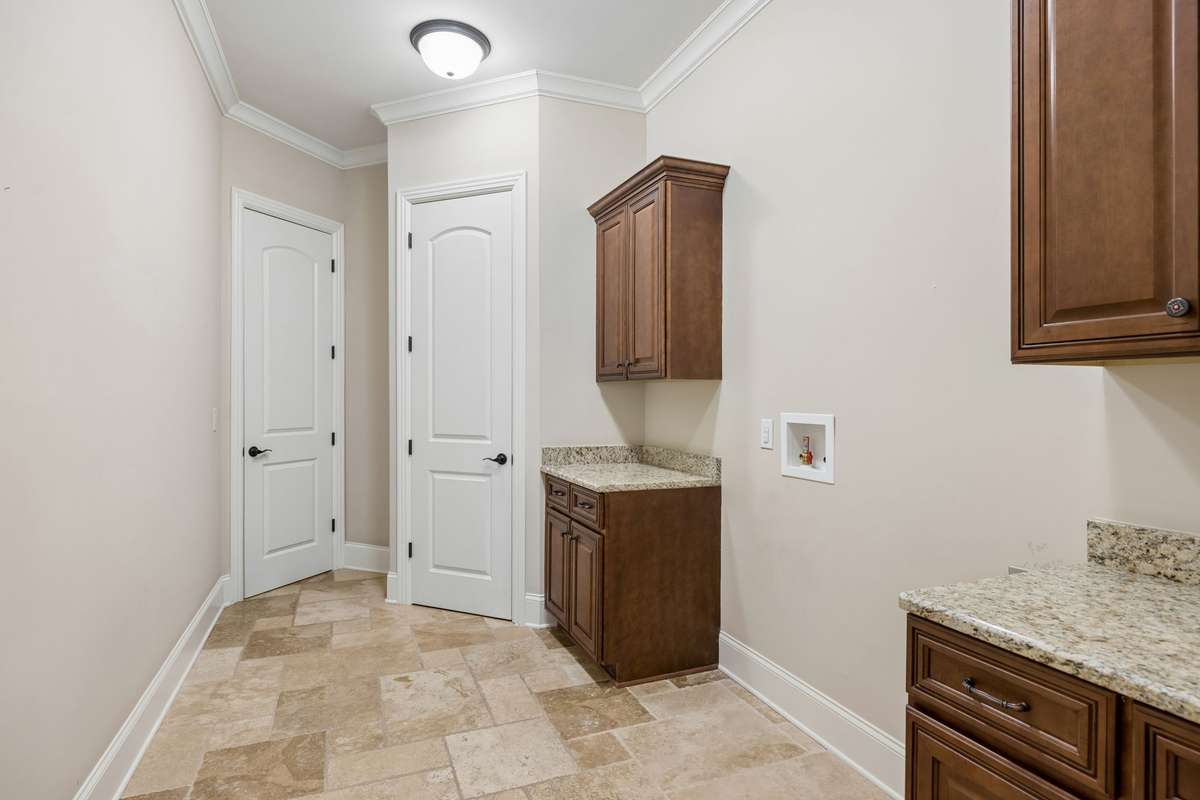 Large laundry room with broom closet and extra cabinets for storage.  Even room to keep your ironing board set up!