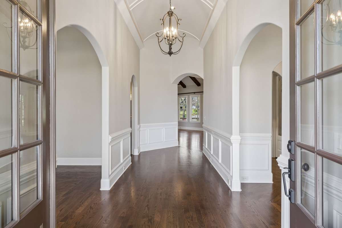 Barrel ceiling foyer with wainscotting panels.  Sand and finish hardwoods.
