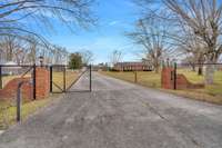 The property features ornamental metal fencing with gated and lighted brick entry.