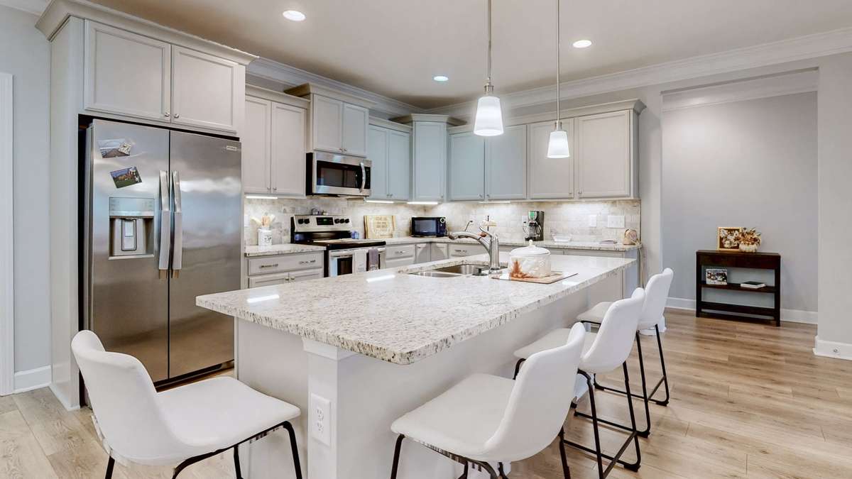 The gourmet kitchen makes cooking fun with extra seating at the large island.  Custom cabinetry and backsplash will make you want to spend all your time here.