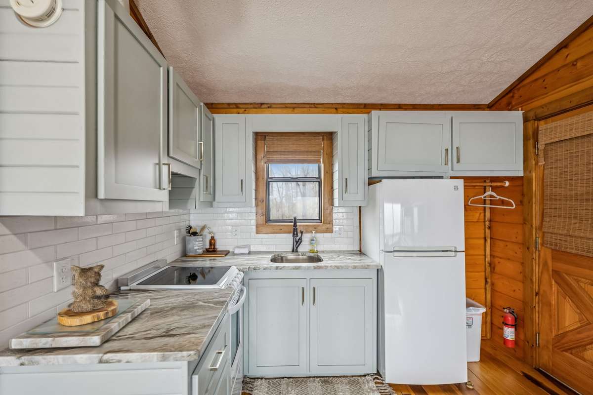 In-law suite kitchenette. Complete with range, refrigerator, sink and freshly painted cabinets.