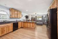 This photo encompasses everything you’ll love about this lovely space — from the beautiful custom cabinets, Corian solid surface countertops, "new and never used" Whirlpool dishwasher, to the open flow into the living area.
