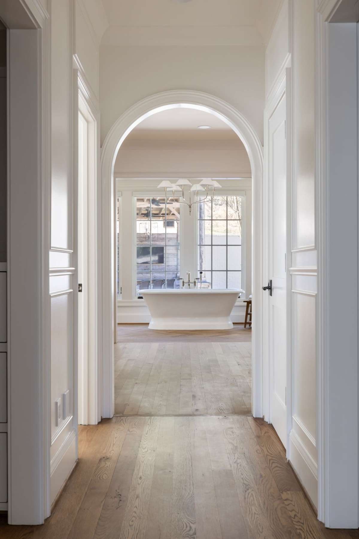 Arched passage leading to the primary bath with soaking tub