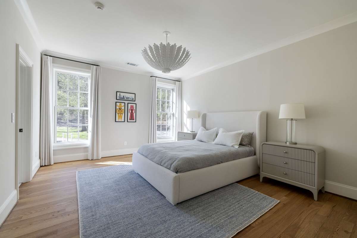Light-filled bedroom on second level with hardwood flooring and refined, neutral finishes