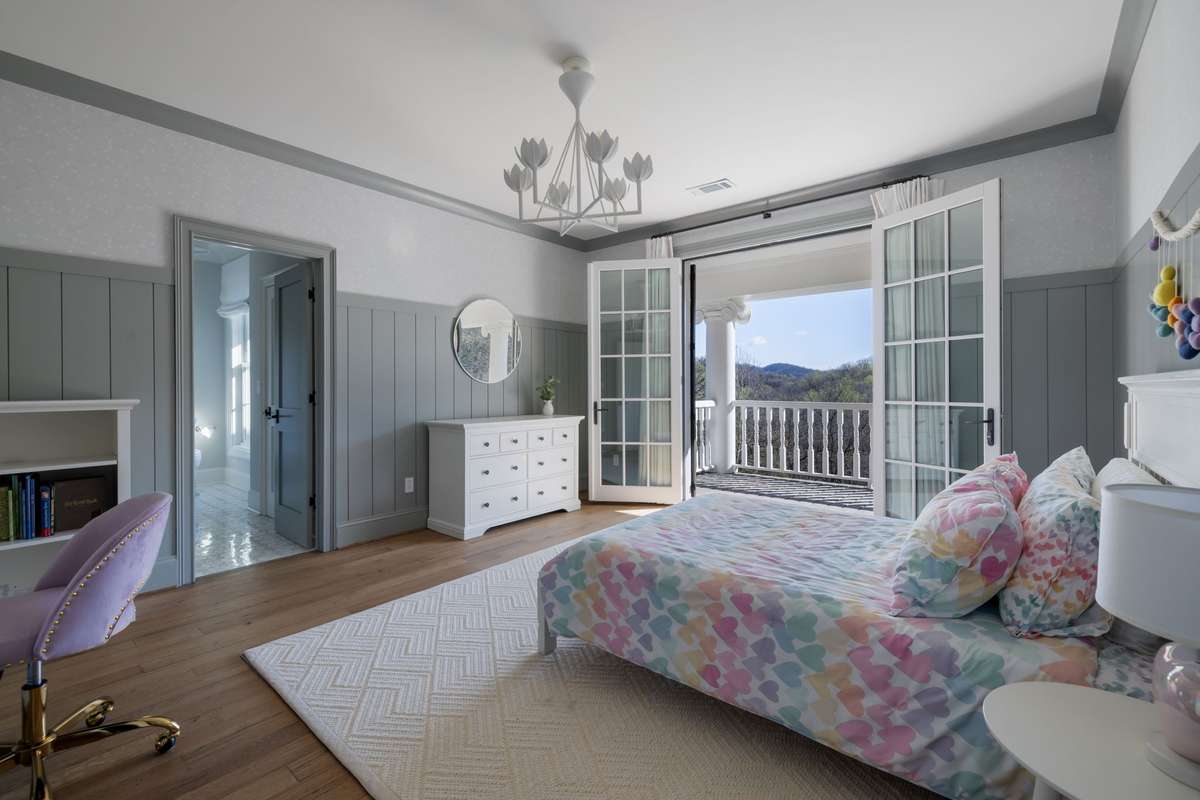 Third upstairs bedroom with custom millwork and balcony access